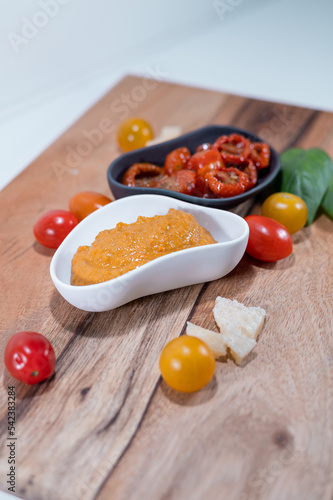 red pesto sun dried tomato sauce basil cheese wood plate