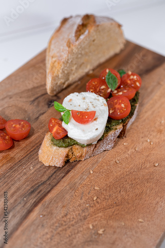 tomato cheese green basil mozzarella bread toast wood table