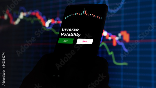 An investor's analyzing the Inverse Volatility etf fund on screen. A phone shows the ETF's prices stocks to invest
