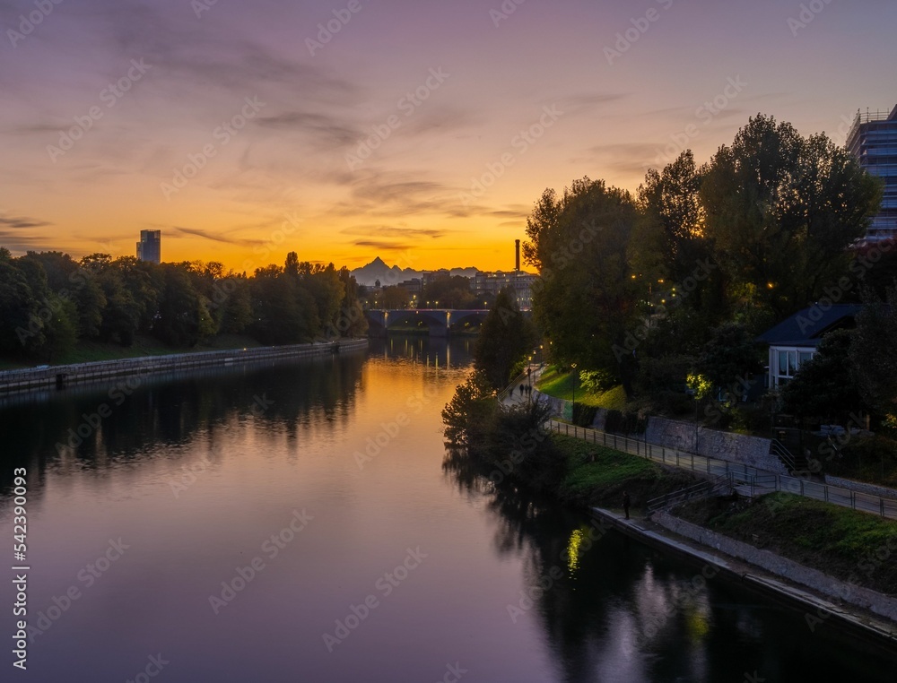 Scenic river running through a town during sunset surrounded by vegetation