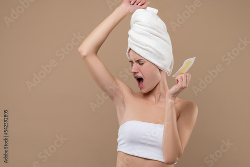 Fotografiet Young woman doing hair removing procedures and feeling upleased