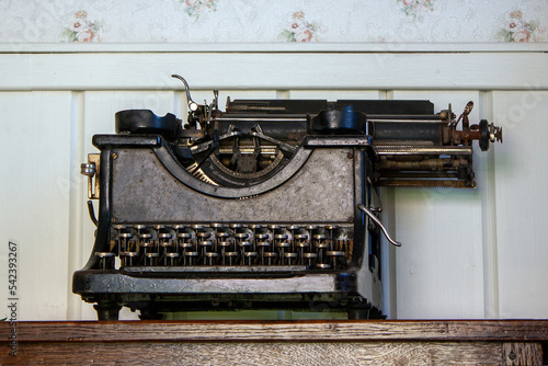 vintage typewriter stands on a wooden nightstand