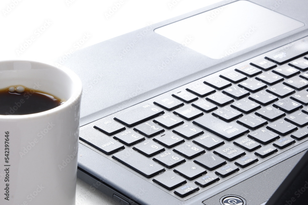 コーヒーを飲みながらノートパソコン(黒)でデスクワーク コーヒーを飲みながらノートパソコン(黒)でデスクワーク