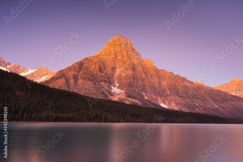 Mountain landscape at dawn. Sunbeams in a valley. Lake and forest in a mounta...