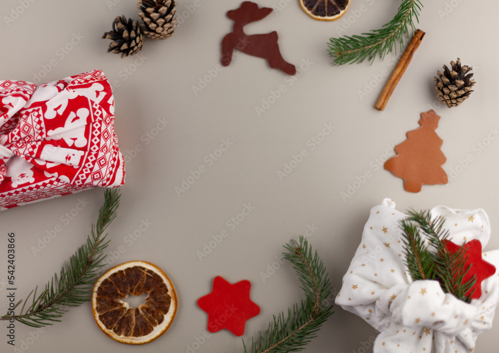 Obraz premium Eco-friendly Christmas composition with gift boxes made of eco-friendly reusable materials and natural decor on a gray background. The concept of Christmas with zero waste.