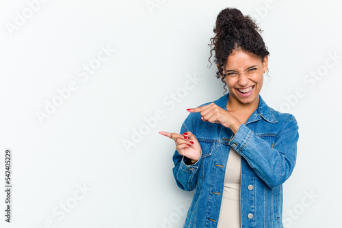 Young african american woman isolated pointing with forefingers to a copy space, expressing excitement and desire.