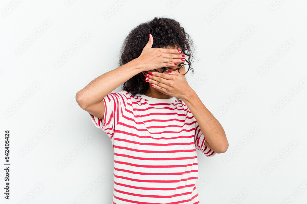 Young african american woman isolated blink at the camera through fingers, embarrassed covering face. Young african american woman isolated blink at the camera through fingers, embarrassed covering face.