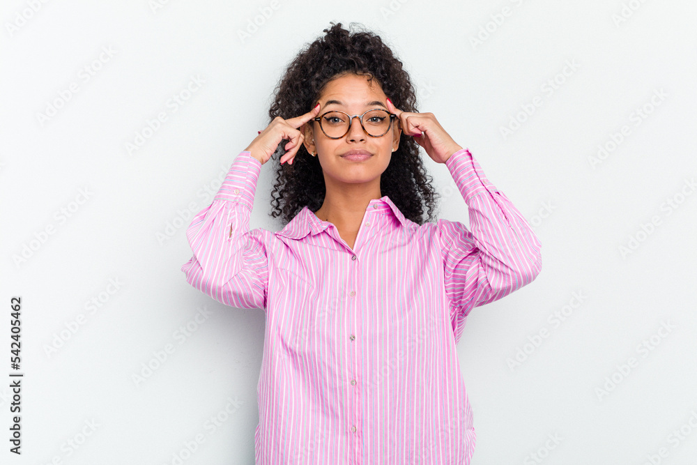 Young african american woman isolated focused on a task, keeping forefingers pointing head.
