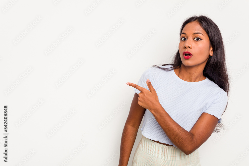 Young Indian woman isolated on white background smiling and pointing aside, showing something at blank space. Young Indian woman isolated on white background smiling and pointing aside, showing something at blank space.