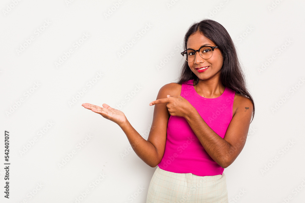 Young Indian woman isolated on white background excited holding a copy space on palm. Young Indian woman isolated on white background excited holding a copy space on palm.