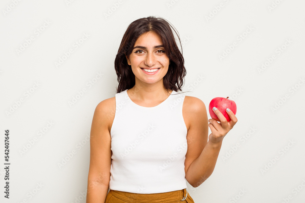 Young Indian woman holding an apple isolated on white background happy, smiling and cheerful. Young Indian woman holding an apple isolated on white background happy, smiling and cheerful.
