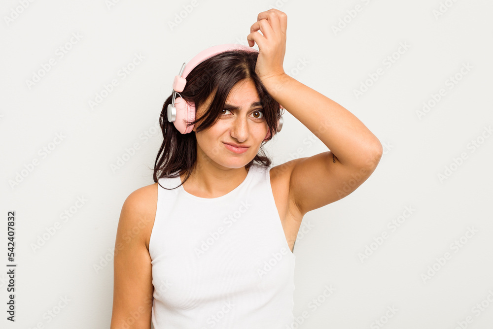 Young Indian woman wearing headphones isolated on white background being shocked, she has remembered important meeting. Young Indian woman wearing headphones isolated on white background being shocked, she has remembered important meeting.