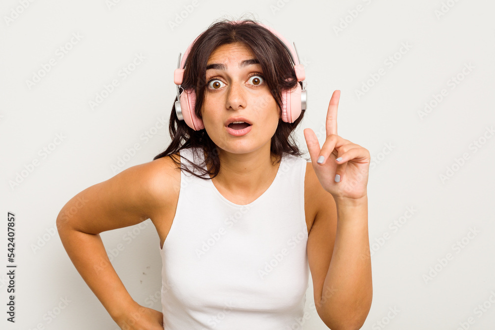 Young Indian woman wearing headphones isolated on white background having an idea, inspiration concept. Young Indian woman wearing headphones isolated on white background having an idea, inspiration concept.