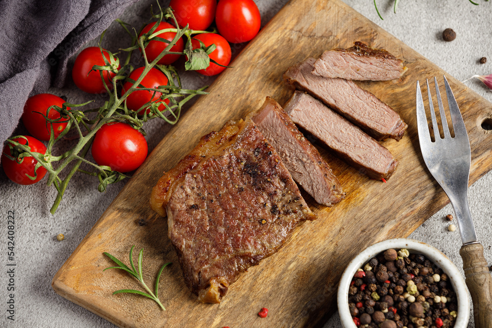 Grilled sliced beef steak well done on wooden cutting board. Top view. Grilled sliced beef steak well done on wooden cutting board. Top view.