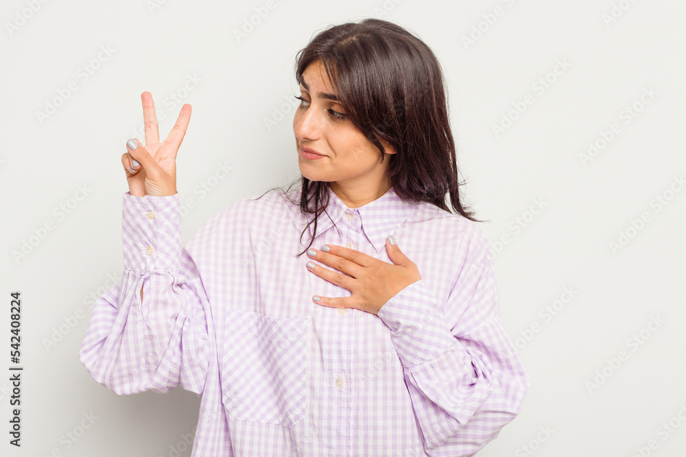 Young Indian woman isolated on white background taking an oath, putting hand on chest. Young Indian woman isolated on white background taking an oath, putting hand on chest.