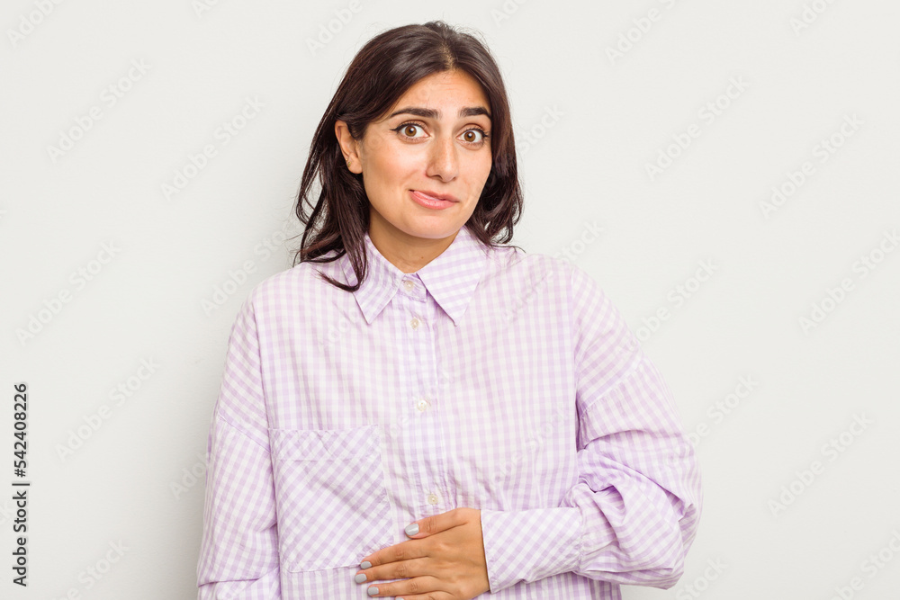 Young Indian woman isolated on white background touches tummy, smiles gently, eating and satisfaction concept. Young Indian woman isolated on white background touches tummy, smiles gently, eating and satisfaction concept.