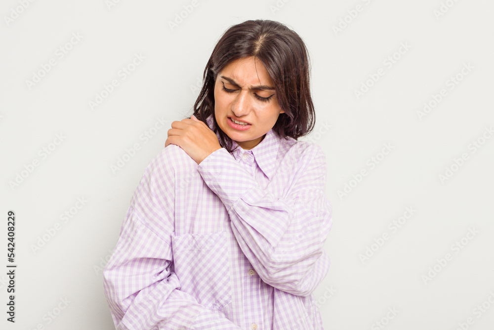 Young Indian woman isolated on white background having a shoulder pain. Young Indian woman isolated on white background having a shoulder pain.