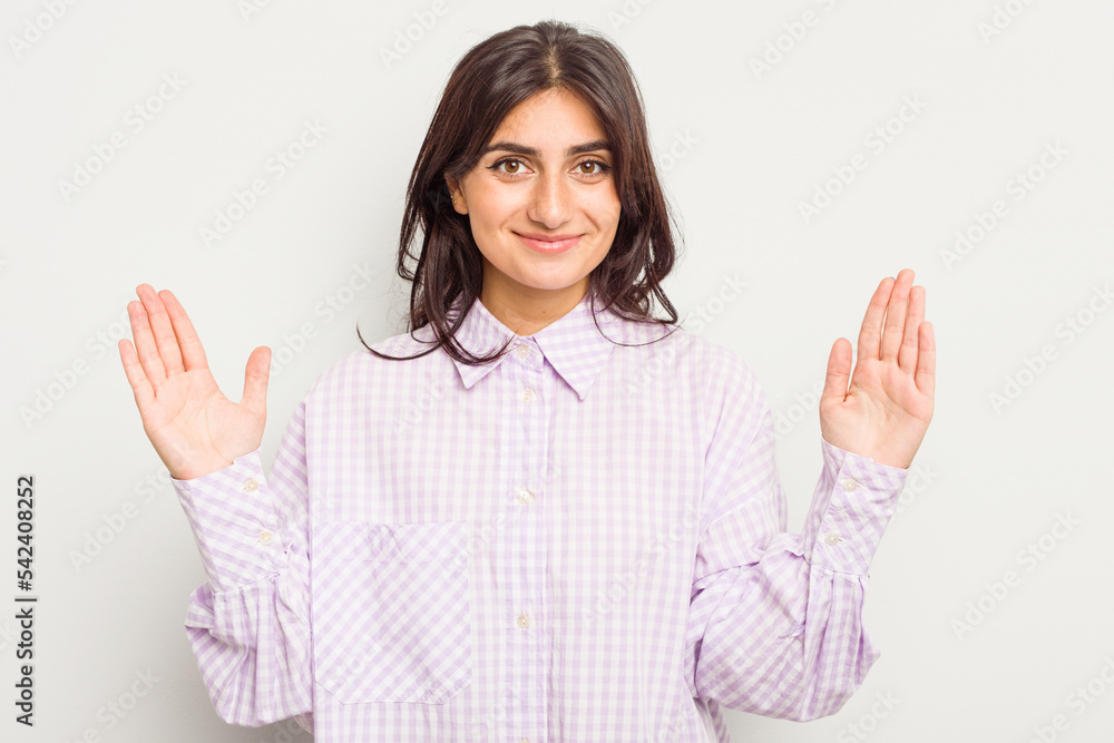Young Indian woman isolated on white background holding something little with forefingers, smiling and confident. Young Indian woman isolated on white background holding something little with forefingers, smiling and confident.