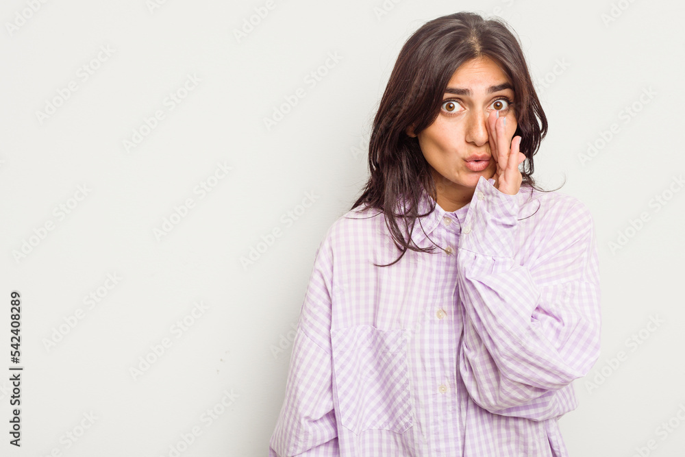 Young Indian woman isolated on white background is saying a secret hot braking news and looking aside Young Indian woman isolated on white background is saying a secret hot braking news and looking aside