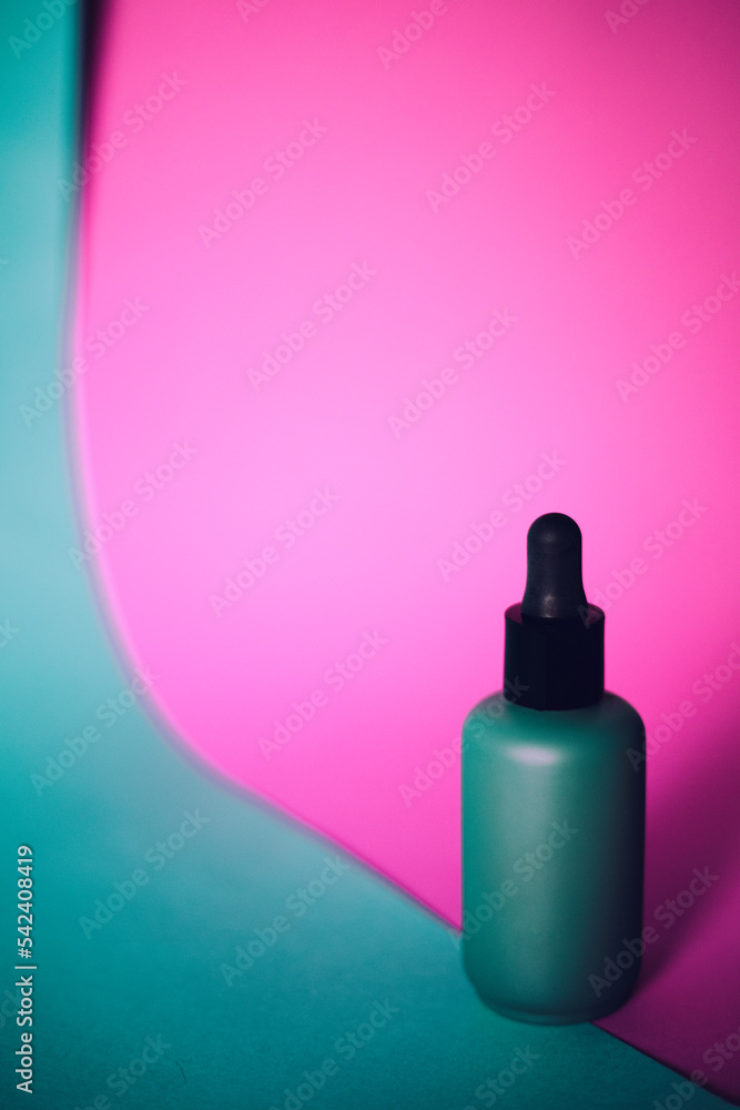 Skin care lotion or serum on pink background.