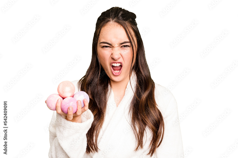 Young caucasian woman holding aromatic balls for bathtub isolated on green chroma background screaming very angry and aggressive. Young caucasian woman holding aromatic balls for bathtub isolated on green chroma background screaming very angry and aggressive.