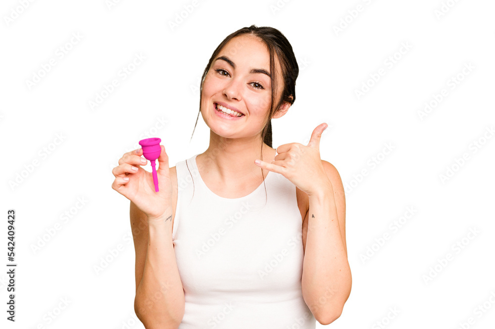 Young caucasian woman holding menstrual cup isolated on green chroma background showing a mobile phone call gesture with fingers.