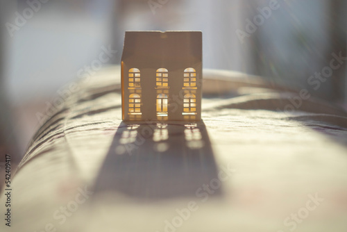 Tea light house illuminated by natural back light creating a nice shadow. Hygge feeling.