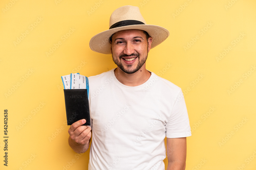 Young latin man holding a flight tickets for vacations laughing and having fun. Young latin man holding a flight tickets for vacations laughing and having fun.