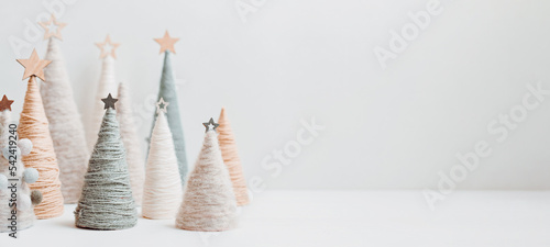 Christmas craft background with handmade yarn cone xmas trees in natural colors. photo