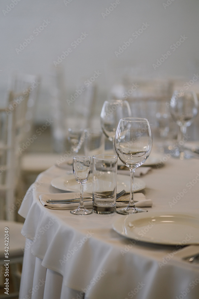 Fototapeta premium Glasses with champagne are on the table, table setting in a restaurant for a banquet