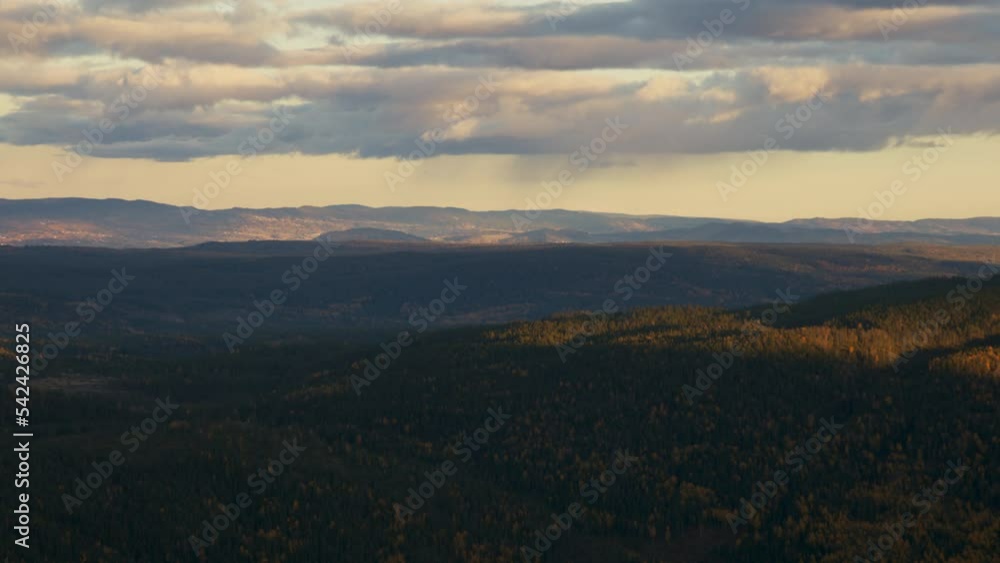 Rainclouds passing over hills of autumn colours. Sunbeams breaking through the clouds and dancing over the mountains. Rainclouds passing over hills of autumn colours. Sunbeams breaking through the clouds and dancing over the mountains.