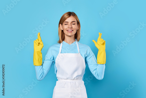 Φωτογραφία woman in rubber gloves with finger crossed gesture