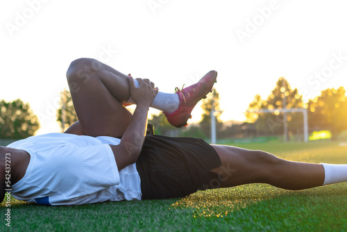 Bilde på lerret closeup of a latin soccer player lying on the ground complaining about a soccer
