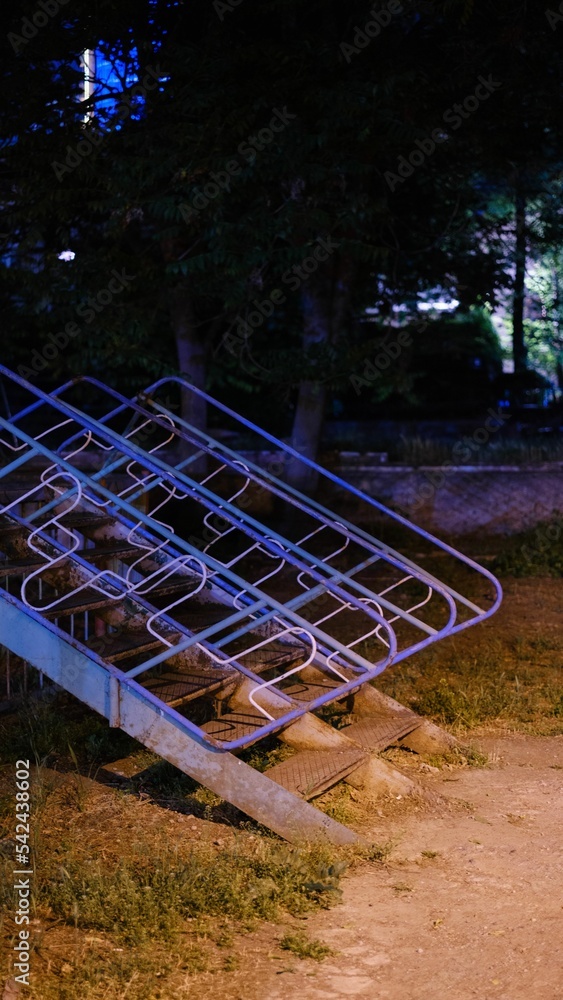 Vertical shot of an old playground at night with rusty steps leading to a children's slide Vertical shot of an old playground at night with rusty steps leading to a children's slide