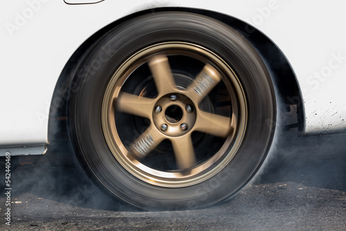 Obraz na plátne Car wheel spinning wheel and smoking, Race car doing lot of smoke on race track, Car wheel drifting and smoking on track