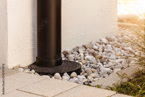 French drain Water Drainage pipe with water Stones Gravel aroud House  
