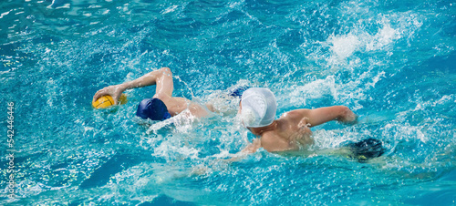 Young men play water polo in a swimming pool