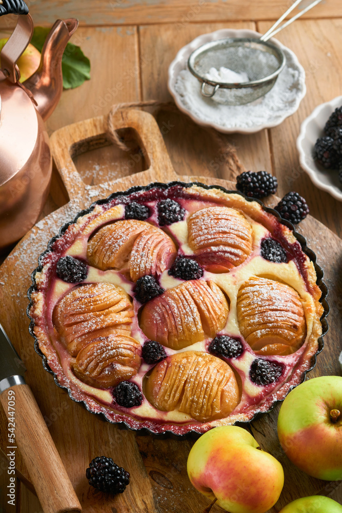 Apple pie. Apple and blackberries cake or pie decorated sugar powder on old wooden table. Delicious dessert for autumn or winter dinner. Autumn pastry dessert. Soft focus. Apple pie. Apple and blackberries cake or pie decorated sugar powder on old wooden table. Delicious dessert for autumn or winter dinner. Autumn pastry dessert. Soft focus.