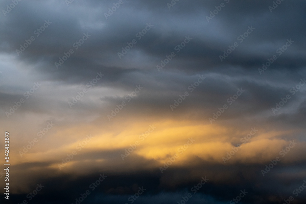 Dark cloud before raining storm and have the orange cloud that reflect light from sunset as background Dark cloud before raining storm and have the orange cloud that reflect light from sunset as background