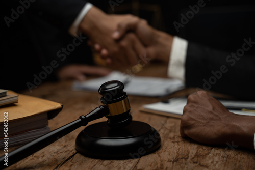 Close up lawyer businessman working or reading lawbook in office workplace for consultant lawyer concept.Lawyer working at table in office, focus on scales of justice © PaeGAG