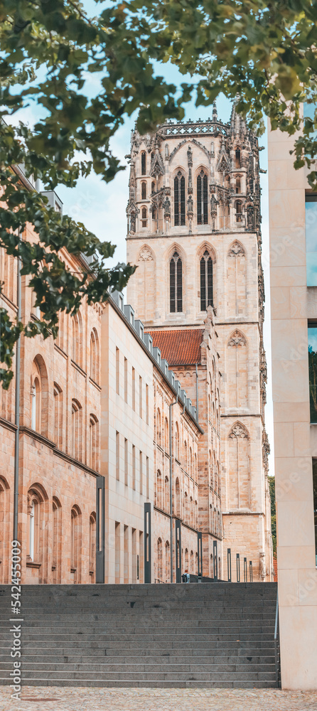 Old town street with Liebfrauen or Uberwasserkirche church and library in Munster, Germany. City life and travel concept