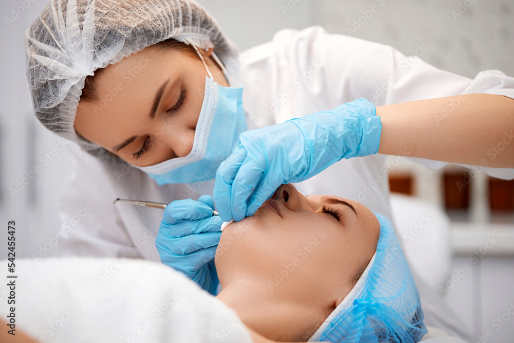 woman during a mechanical face cleansing procedure woman during a mechanical face cleansing procedure