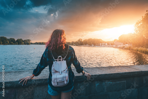 Tablou canvas A student girl with a backpack stands near the embankment of Lake Aasee in Munst