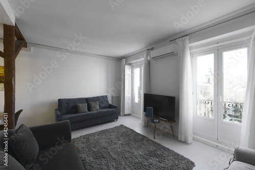 Photography Living room with balconies facing the street with white curtains, wooden beams a