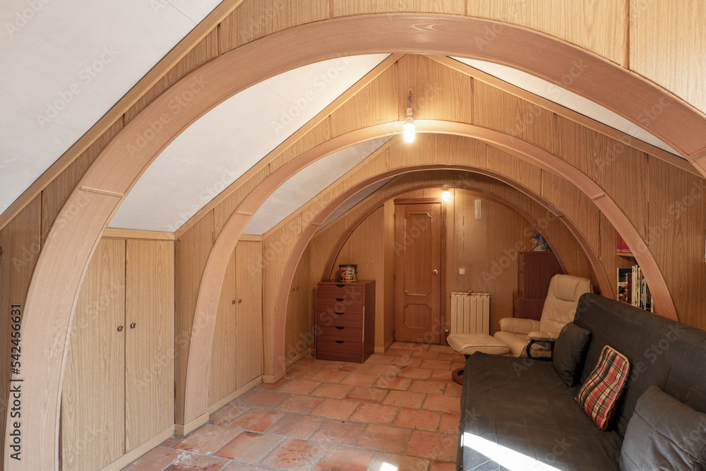 Curious room located in an attic with semicircular arches covered with wood
