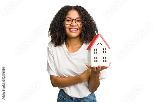 Obraz na plátně Young african american woman moving to a new home while picking up a box full of things isolated laughing and having fun