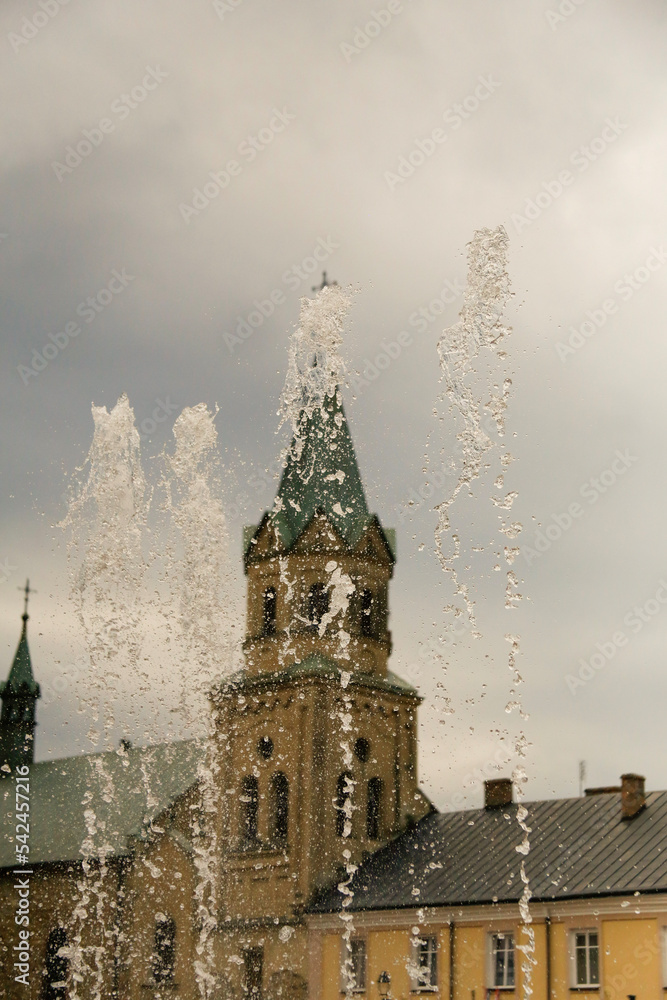 Fototapeta premium gushing fountain against the background of the church
