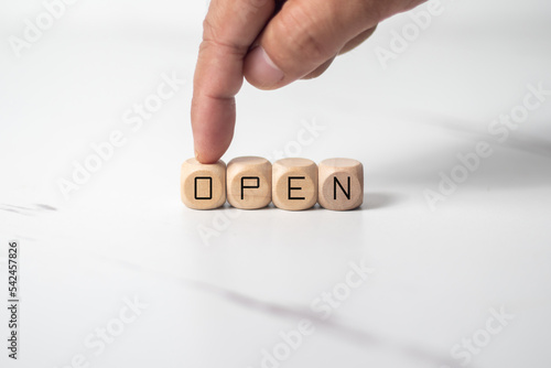 wooden dice on white table with open text