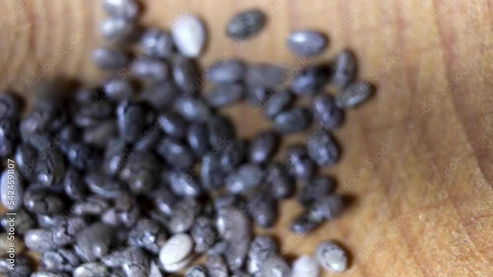 Close-up. Falling chia seeds. Rolling focus through. Chia grain texture. Close-up. Falling chia seeds. Rolling focus through. Chia grain texture.