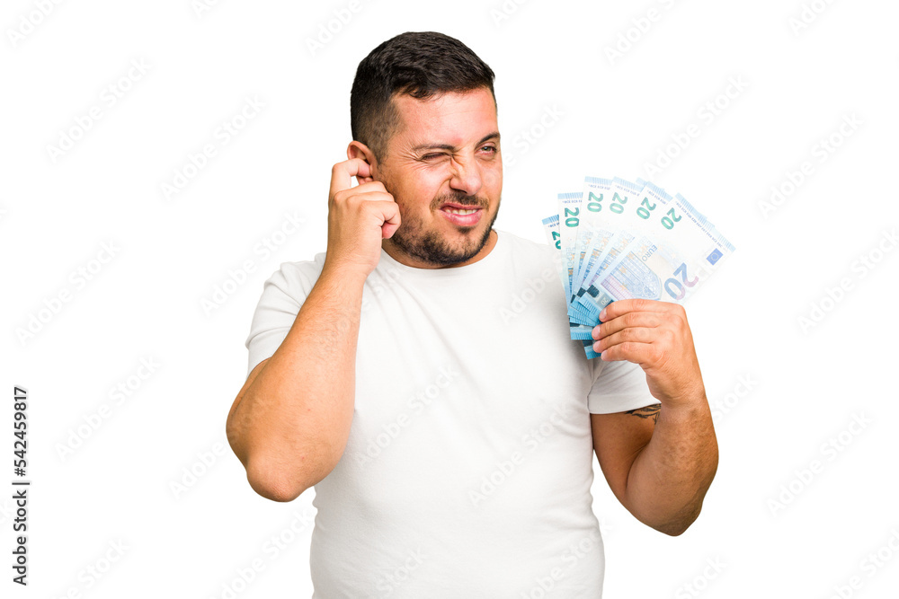 Young caucasian man holding a banknotes isolated covering ears with hands. Young caucasian man holding a banknotes isolated covering ears with hands.